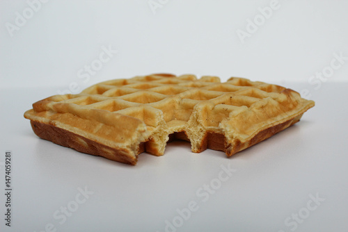 One bitten waffle cake, isolated on white background