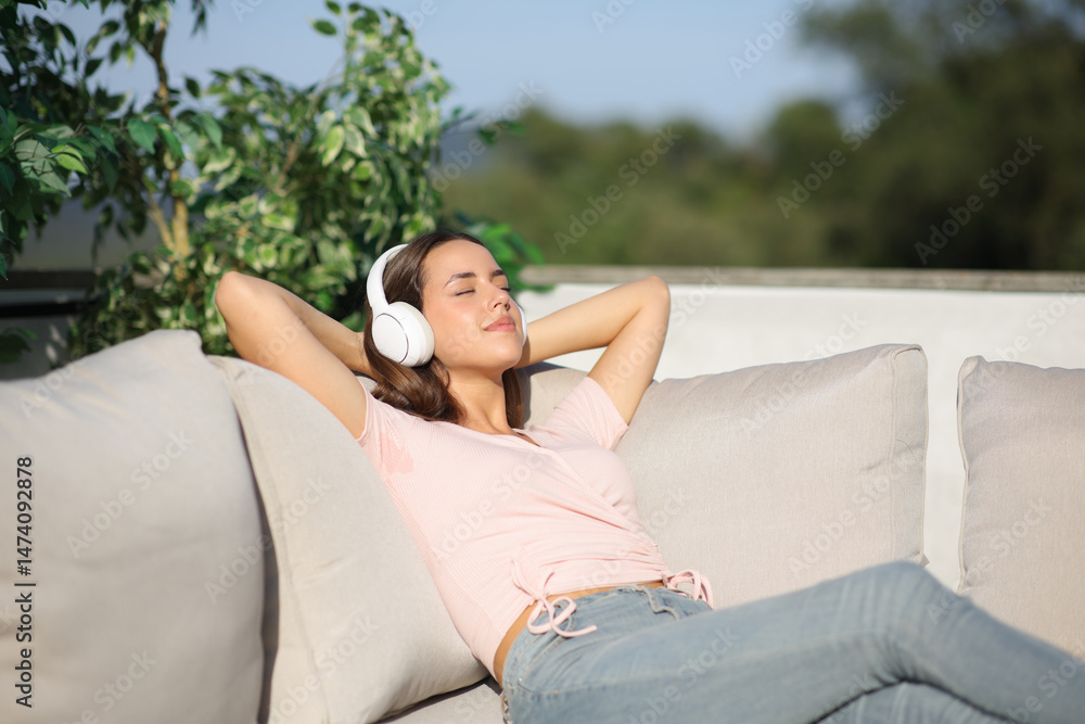 Fototapeta premium Happy woman relaxing listening audio with headphone outside