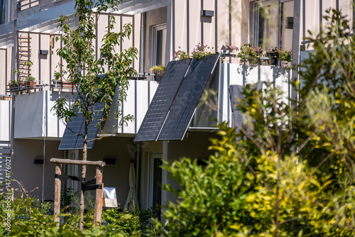 Modernes Balkonkraftwerk mit Solarpanels an einem Mehrfamilienhaus im Sommer, nachhaltige Energiegewinnung im urbanen Raum, grünes Wohnen und erneuerbare Energien.