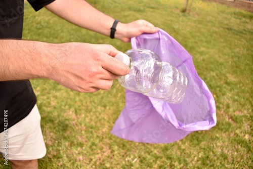 Disposing plastic in trash can outdoors. Sustainable behavior in public space.
