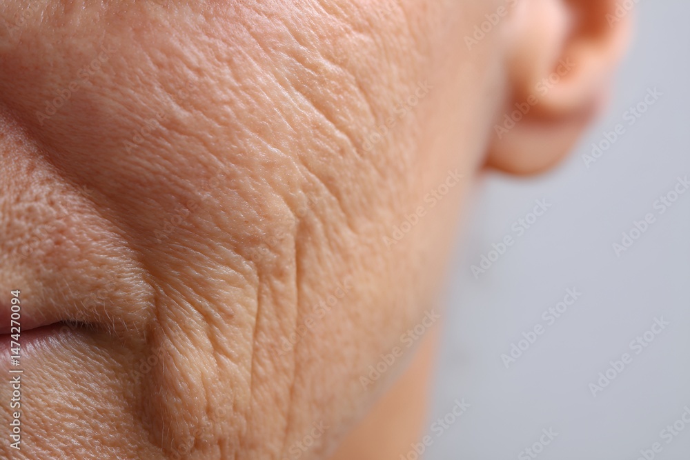 Fototapeta premium Close-up of part of an elderly woman's face, focusing on the wrinkled texture of her skin.
