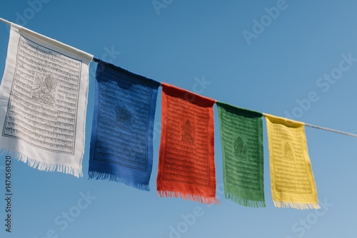 Obraz na płótnie Buddhist prayer flags with mantras and symbols waving in the wind against a clear blue sky w salonie