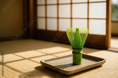 Obraz na płótnie Green bamboo chasen matcha whisk standing on a ceramic tray on a tatami mat, in a traditional Japanese tea room with sunlight shining through shoji doors w salonie