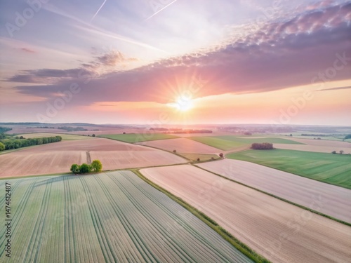 Stunning Aerial View of Lush Green Farmland with Rolling Hills at Sunrise