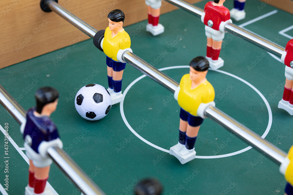 Fototapeta premium A close-up shot of a foosball game in progress. The focus is on the players and the ball.