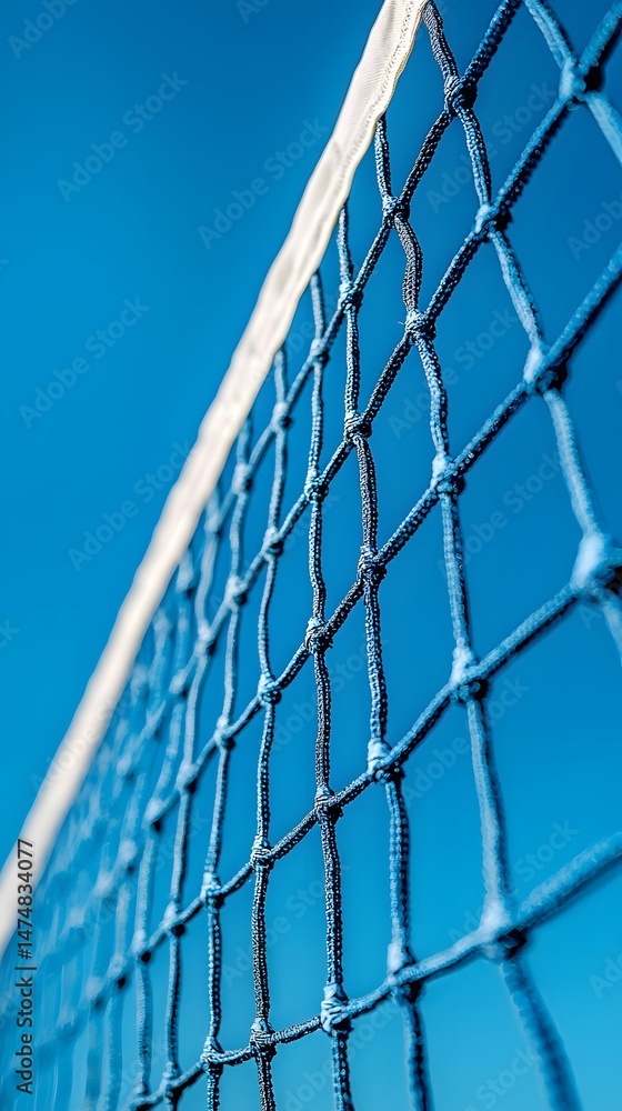 A close up perspective looks up at a volleyball net silhouetted against a cloudless bright blue sky on a beautiful sunny day, inviting recreation and sport. A close up perspective looks up at a volleyball net silhouetted against a cloudless bright blue sky on a beautiful sunny day, inviting recreation and sport.
