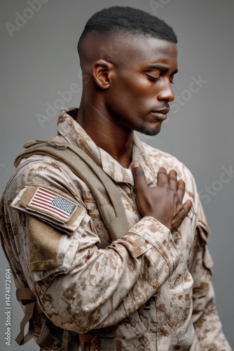 Military man salutes with pride during a solemn moment in uniform, showcasing dedication and honor on a neutral backdrop