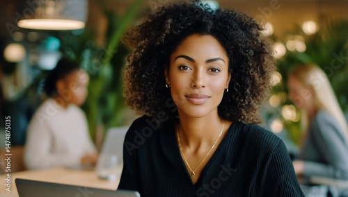 Young Woman Smiling While Working on Laptop in a Modern Cafe During Daytime