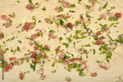 Obraz na płótnie Raw dough is topped with diced pancetta, green herbs, and possibly olive oil in preparation for making pancetta rolls w salonie
