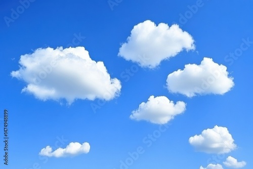 Fototapeta Naklejka Na Ścianę i Meble -  Fluffy white cumulus clouds scattered across a vibrant cerulean blue sky