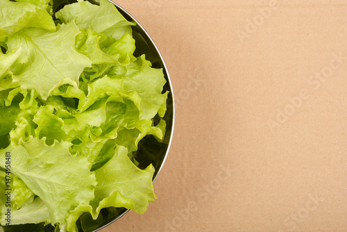Obraz na płótnie A top-down close-up shows fresh, vibrant green lettuce leaves filling a round stainless steel bowl w salonie