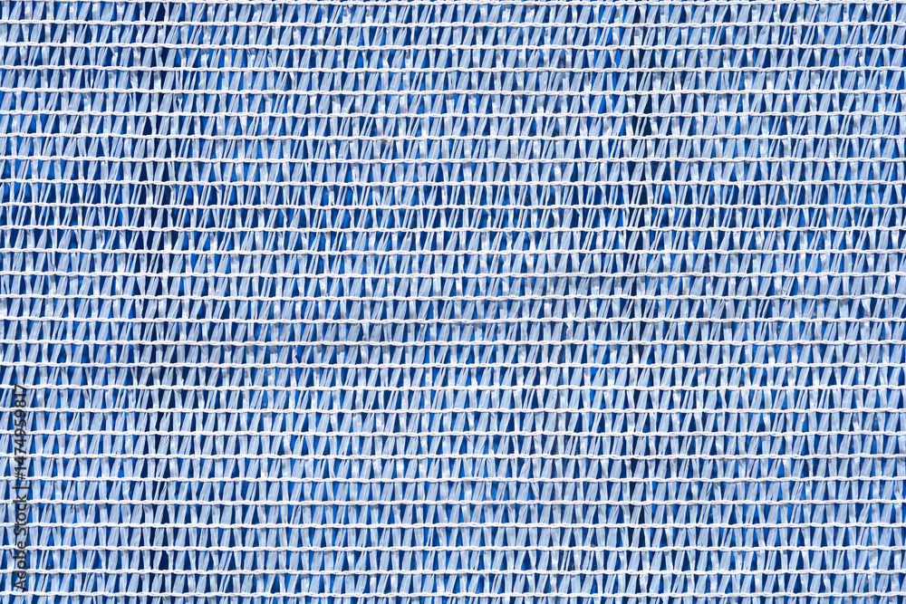 A close-up shows a textured white plastic netting laid over a blue surface, creating a striped pattern