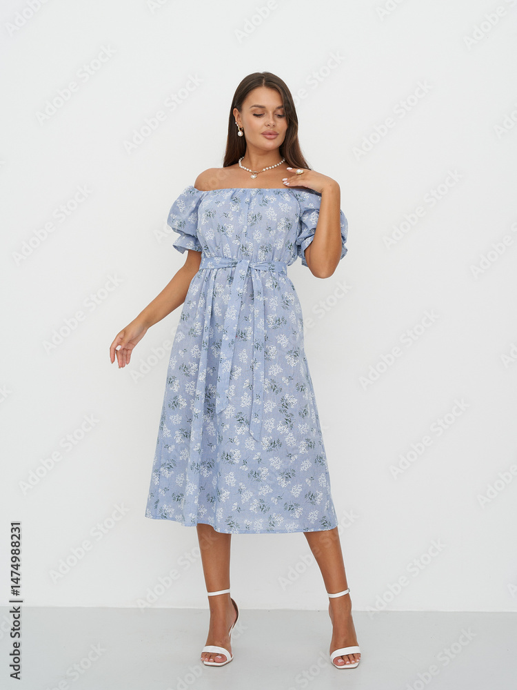 Fototapeta premium Fashion model showcases elegant blue dress in creative studio setting