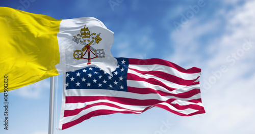Fotografie Vatican city flag waving in the wind with the American flag on a clear day