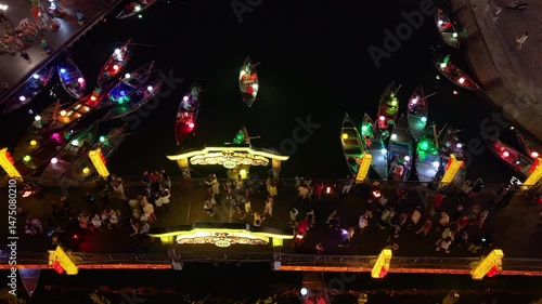 Drone footage capturing the Hoi An Lantern Festival at night, with floating lanterns, boats, and tourists along the river. Ideal for cultural, travel, and festive content