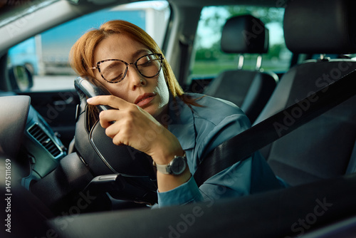 Exhausted businesswoman napping after long car ride.
