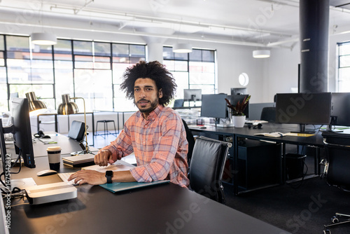 Confident businessman in modern office working on computer, focusing on tasks