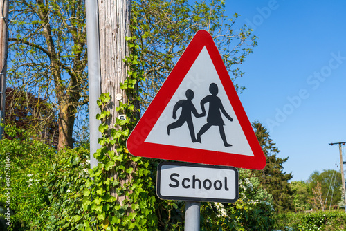 UK Road sign informing drivers they are in an area with a school, School children crossing