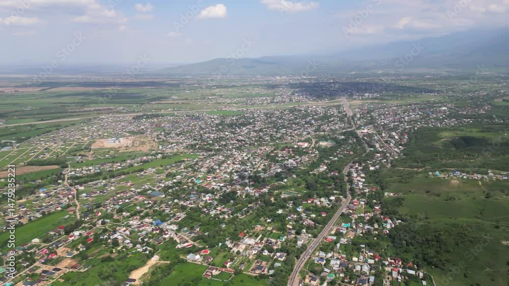 The road is on the outskirts of the city, along villages and houses. The view from the drone. The road is on the outskirts of the city, along villages and houses. The view from the drone.