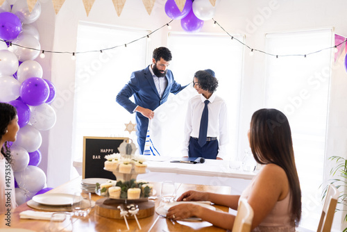Family celebrating bar mitzvah with decorations and festive table setting