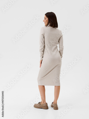 Pregnant girl model in stylish clothes on white background in studio.