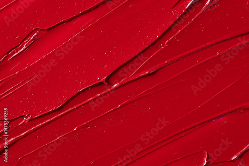 Rich red lipstick texture with smooth application and glossy finish, showcasing vibrant color and luxurious feel for beauty and cosmetic themes. Red lipstick background.