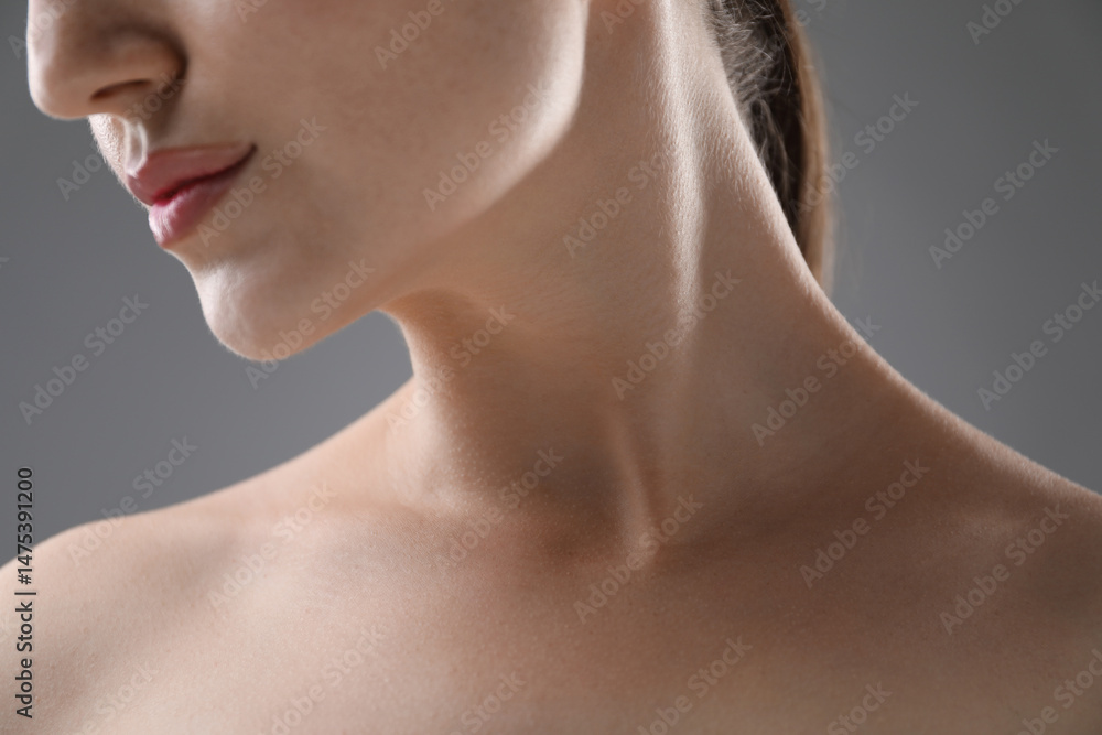 Woman with beautiful collarbones and neck on grey background, closeup Woman with beautiful collarbones and neck on grey background, closeup
