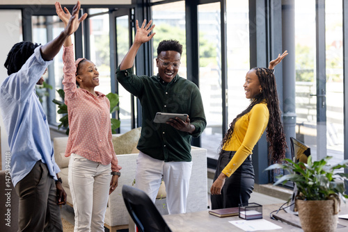 Photos African American colleagues celebrating success with high fives in modern office