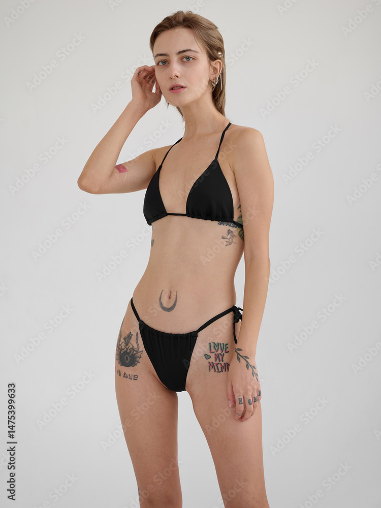 Fototapeta premium Girl model posing in studio on light background.