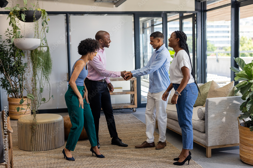 Fototapeta premium Colleagues greeting each other with handshake in modern office lounge area