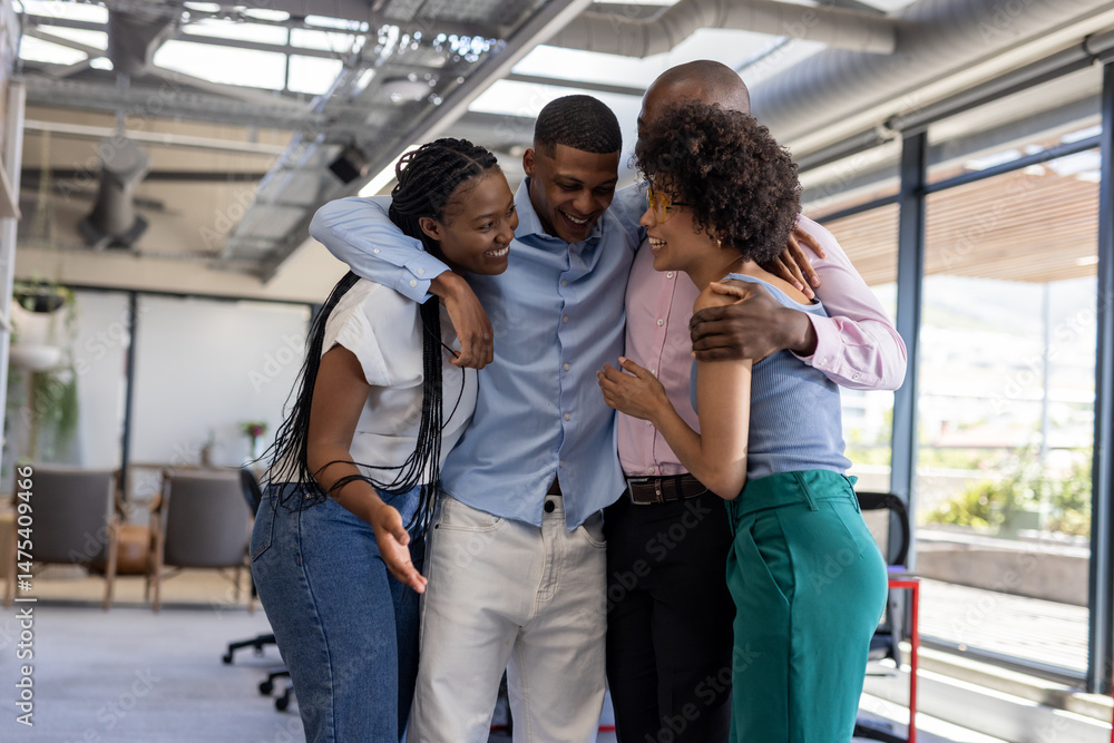 Obraz premium Diverse colleagues in office hugging and laughing, celebrating team success together