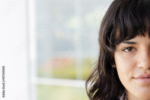 Close-up of woman with dark hair looking confidently at camera indoors Free Download Close-up of woman with dark hair looking confidently at camera indoors - GFXLoad