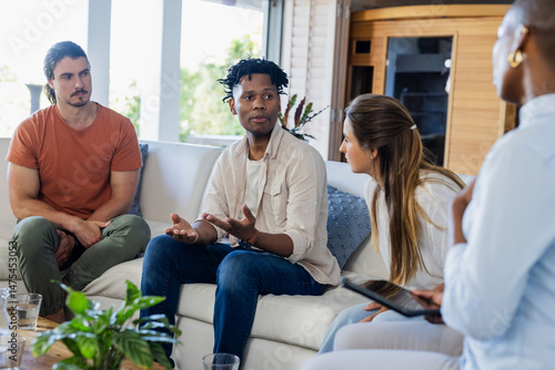 Discussing ideas, diverse friends sharing insights in thoughtful home conversation