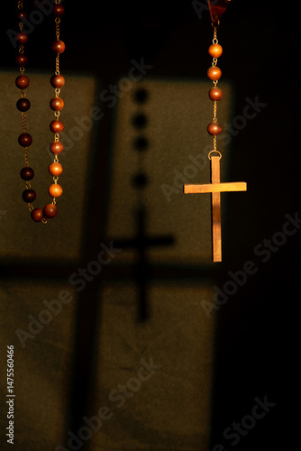 Obraz na płótnie Wooden rosary, beautiful and large antique rosary under the light of a window and with a black background, selective focus. w salonie
