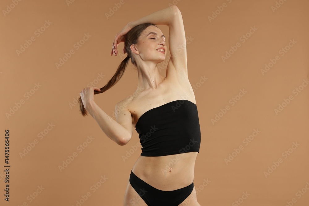 Obraz premium Beautiful woman with perfect slim body on beige background