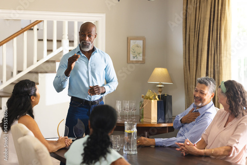 Tableau sur toile Giving speech at family gathering, African American man, everyone smiling attent