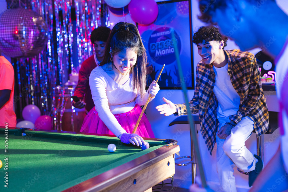 Fototapeta premium Teenagers playing pool at party, enjoying vibrant celebration with friends