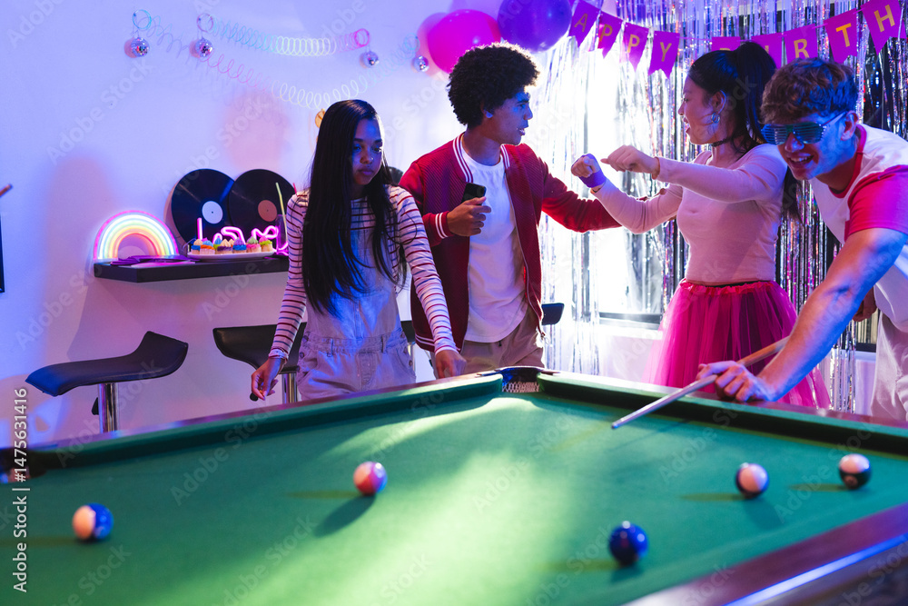 Fototapeta premium Teenagers playing pool and celebrating birthday in colorful party room