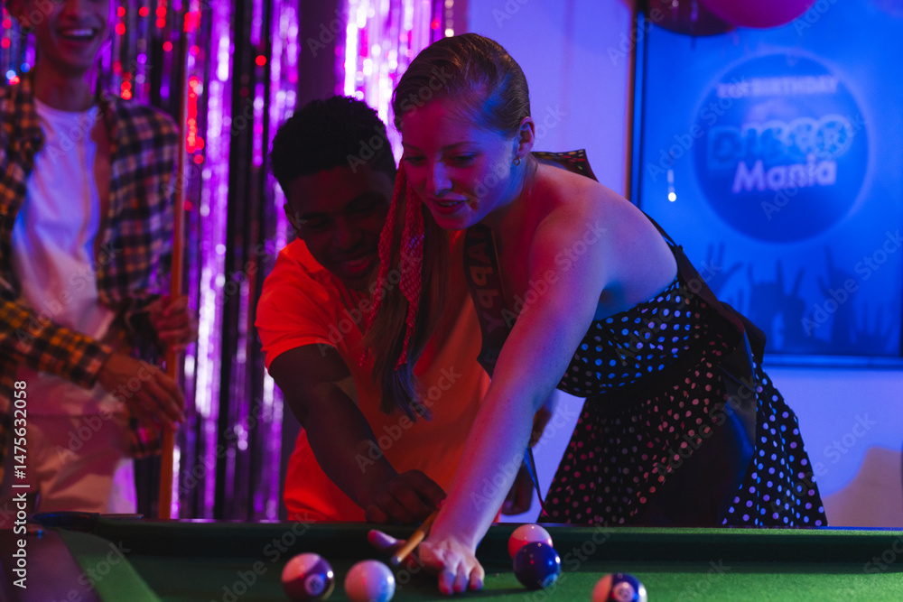 Fototapeta premium Teenagers playing pool at birthday party, enjoying lively celebration atmosphere