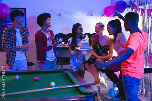 Teens celebrating birthday with cake and decorations in lively party atmosphere