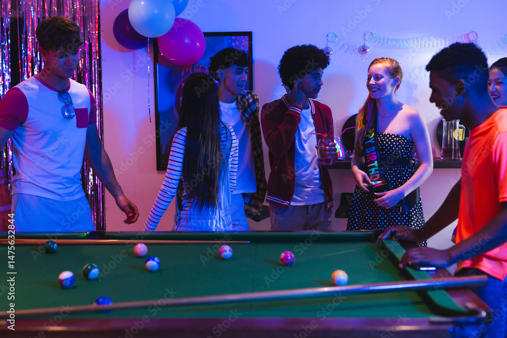 Fototapeta premium Teenagers enjoying lively pool game at home party with colorful decorations