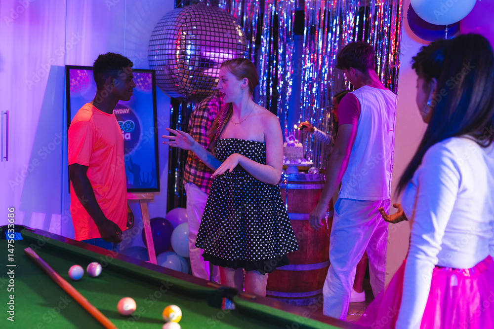Fototapeta premium Teenagers enjoying lively party with pool table and disco ball decorations