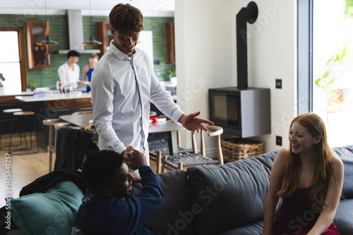 Teen friends celebrating at home, laughing and enjoying time together on sofa
