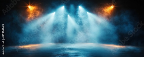 Empty stage illuminated by bright blue and warm orange spotlights creating a misty and dramatic atmosphere