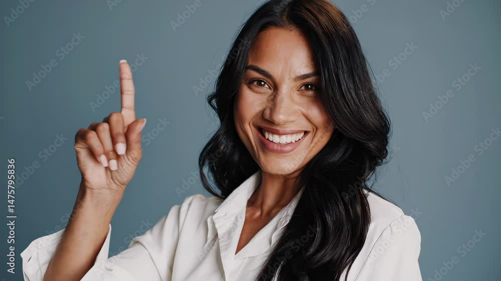Confident woman gesturing number one with smiling expression in studio setting Confident woman gesturing number one with smiling expression in studio setting