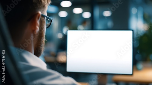 Man working at a computer with blank screen in modern office space