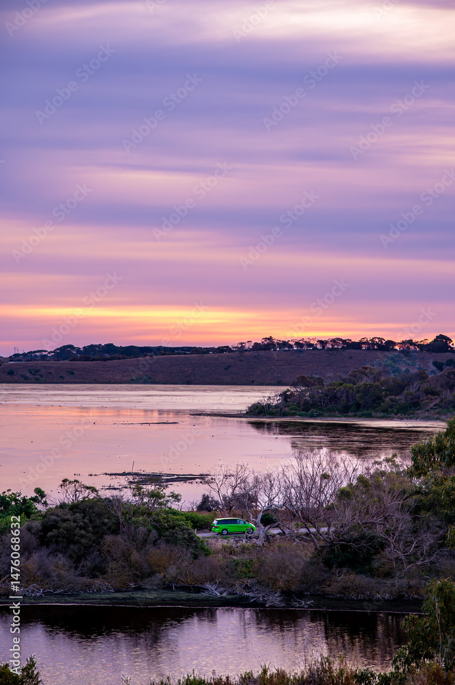 Fototapeta premium Amazing sunset over the lakes with a car driving between lakes, Tower Hill, Victoria, Australia