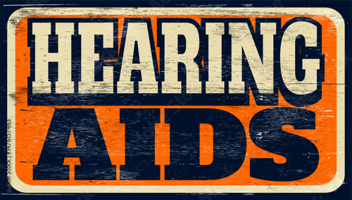 Aged and worn hearing aids sign on wood