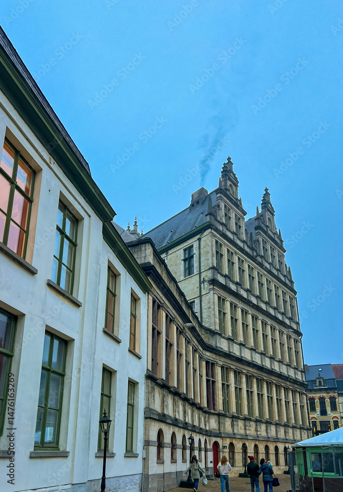 Obraz premium Historic town hall of Ghent: stunning stone facade against blue sky