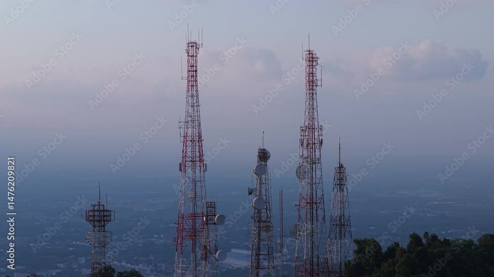 Group of communication towers on a hill, providing telecommunications over a hazy landscape and distant view. Group of communication towers on a hill, providing telecommunications over a hazy landscape and distant view.